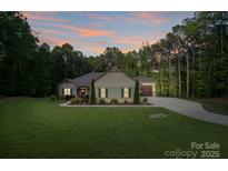 Charming single-story home with a well-manicured lawn and lovely landscaping at 7358 Bay Cove Ct, Denver, NC 28037
