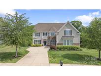 Charming two-story home with a well-manicured lawn, inviting curb appeal, and traditional architectural design at 7405 Albemarle Dr, Denver, NC 28037