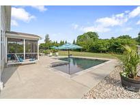 Inviting pool with an umbrella, screened porch, and lounge chairs, set in a spacious backyard at 7405 Albemarle Dr, Denver, NC 28037