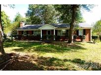 Charming one-story brick home with a well-maintained lawn and mature trees at 8205 Meadowind Cir, Charlotte, NC 28226