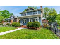Charming blue two-story home with inviting front porch and meticulously maintained landscaping at 822 W Front St, Statesville, NC 28677