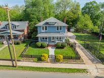 Charming blue two-story home featuring a well-manicured front yard with a classic picket fence at 822 W Front St, Statesville, NC 28677