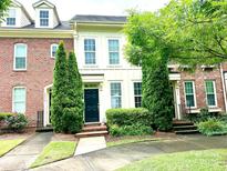 Charming townhome with manicured landscaping, a striking black door, and a welcoming facade at 9832 Longstone Ln, Charlotte, NC 28277