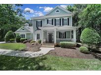 Charming two-story home featuring a welcoming front porch and beautifully landscaped front yard at 128 Spears Creek Dr, Mooresville, NC 28117