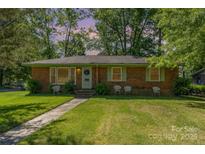 Charming brick ranch home with a neatly landscaped front yard and sidewalk at 1301 Burnwick Ct, Charlotte, NC 28213