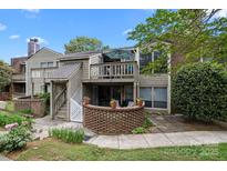 Charming townhouse with brick accents, a second-floor balcony, and manicured landscaping at 1608 Sharon W Rd # 55, Charlotte, NC 28210