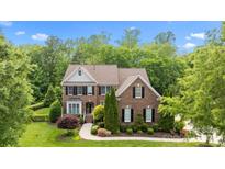 Beautiful two-story brick home with manicured lawn and mature landscaping at 2025 Groves Edge Ln, Waxhaw, NC 28173