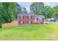 Charming brick home with black shutters, green lawn, and wooden fence at 3219 Spring Valley Dr, Gastonia, NC 28052