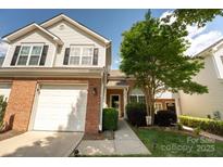 Charming townhouse featuring a one-car garage, red brick accents, and a well-manicured lawn at 3412 Summerfield Ridge Ln, Matthews, NC 28105