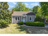 Charming one-story home features a manicured lawn, mature trees, and a welcoming front entrance at 3612 The Plz, Charlotte, NC 28205