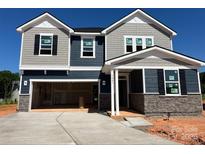 Two-story home with gray and blue siding, stone accents, and an attached two-car garage at 1001 Cunningham Farm Dr, Indian Trail, NC 28079