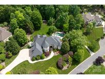 Stunning aerial view of estate home featuring backyard pool surrounded by mature trees and lush landscaping at 1001 Medinah Ct, Waxhaw, NC 28173