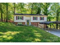 Charming split-level home with red shutters, a brick foundation, and a convenient carport at 1018 Autumn Ln, Hickory, NC 28602