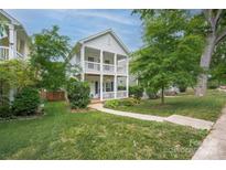 Charming two-story home boasts a double porch, well-manicured lawn, and lush greenery at 12224 Huntersville Concord Rd, Huntersville, NC 28078