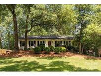 Charming one-story home with a well-manicured lawn and mature trees at 1427 Worcaster Pl, Charlotte, NC 28211