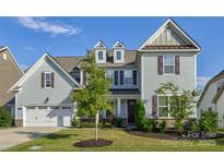 Charming two-story home showcasing a manicured lawn, attached garage, and a welcoming facade with classic architectural details at 15108 Montage Ln, Charlotte, NC 28278