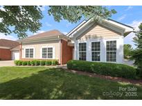 Beautiful home with well-maintained lawn and manicured hedges beneath large windows at 2114 N Castle Ct, Matthews, NC 28105