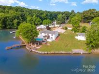 Stunning waterfront home with a private dock and pool overlooking the lake at 235 River Loop Rd, Belmont, NC 28012