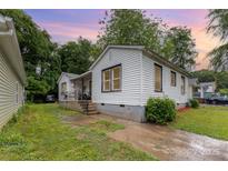 Charming white home with dark trim, showcasing a quaint yard and inviting front porch at 2622 Hemphill St, Charlotte, NC 28208