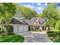 Charming two-story home featuring a three-car garage, well-manicured lawn, and lush landscaping at 3508 Mountain Cove Dr, Charlotte, NC 28216