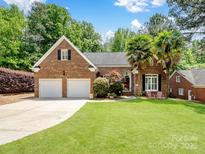 Charming brick home with a lush front lawn, two car garage, and inviting curb appeal at 8128 Sealey Ct, Charlotte, NC 28277