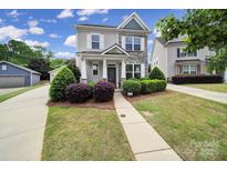 Charming two-story home with stone accents, manicured lawn, and inviting front porch at 8702 Aspinwall Dr, Charlotte, NC 28216