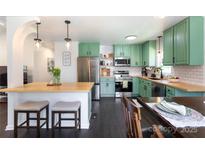 Charming kitchen features stainless steel appliances, butcher block countertops, and unique green cabinets at 109 Hunter Ct, Oakboro, NC 28129
