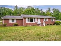 Charming brick home with white shutters and a well-manicured lawn in a serene, wooded setting at 115 Patterson Rd, Kings Mountain, NC 28086