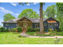Charming blue home with stone accents, covered porch and landscaped front yard at 146 Paradise Peninsula Rd, Mooresville, NC 28117