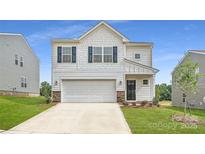 Charming two-story home with a two-car garage and manicured front lawn at 151 Astor St, Troutman, NC 28166