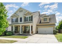 Inviting two-story home with a charming front porch, well-manicured lawn, and a two-car garage at 15807 Foreleigh Rd, Huntersville, NC 28078