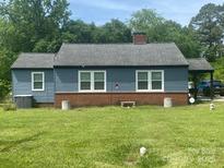 Charming single-story home with blue siding, brick foundation and a large yard at 1658 Hillcrest Ave, Lancaster, SC 29720