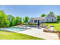 Gorgeous backyard pool with blue umbrellas and lounge chairs in a manicured outdoor space at 1780 Sierra Rd, York, SC 29745