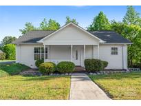 Charming single story home with a welcoming front porch, manicured bushes, and a well-kept lawn at 1806 Red Bird Cir, Concord, NC 28025