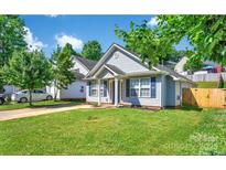 Charming single-story home with blue shutters, well-manicured lawn, and mature trees offering ample shade at 2126 Downing St, Charlotte, NC 28205