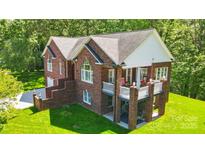 Aerial view of a brick house with a deck, showcasing its architectural design and well-kept outdoor space at 221 Grayrock Dr, Statesville, NC 28677