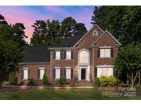 Charming two-story brick home with a manicured lawn, elegant black shutters, and a grand entrance at 2608 Carmarthen Ct, Matthews, NC 28104