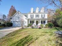 Charming two-story home with a well-manicured lawn, seating, and a welcoming front porch at 5076 Timber Falls Dr, Indian Land, SC 29707