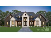 Striking two-story home featuring a gray roof, white brick, dark accents, and a manicured lawn at 611 Wisteria Vines Trl, Fort Mill, SC 29708