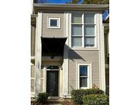 Charming townhouse featuring a covered entryway, large windows, and neutral siding for a modern aesthetic at 1049 Park West Dr, Charlotte, NC 28209