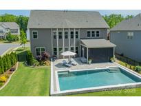 Inviting backyard with a sparkling pool, patio seating, and lush green lawn at 1107 Castle Rd, Indian Land, SC 29707