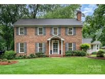 Charming two-story brick home with a well-manicured lawn and symmetrical landscaping at 1209 Alfred St, Charlotte, NC 28211