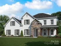 Charming two-story home featuring a brick facade, stone entryway, shuttered windows, and a well-manicured lawn at 12104 Sessile Dr # Oak0015, Mint Hill, NC 28227