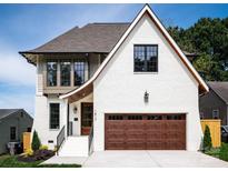 Charming two-story home features a white brick facade, dark trim windows and a spacious two-car garage at 1817 Union St, Charlotte, NC 28205