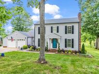 Traditional two-story home with a landscaped yard, attached garage, and a bright blue front door at 208 Wellington Dr, Lincolnton, NC 28092