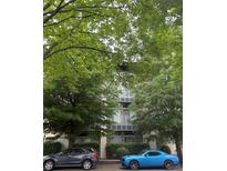 A modern building exterior with large windows and well maintained landscaping and cars parked out front at 2116 Mcclintock Rd # 123, Charlotte, NC 28205