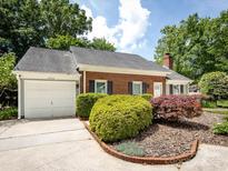 Charming brick home with lush landscaping, featuring a well-manicured lawn and attached garage at 2502 Breuster Dr, Charlotte, NC 28210