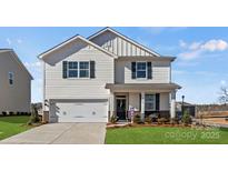 Charming two-story home with attached garage, inviting porch, and beautifully landscaped front yard at 2585 Blue Sky Meadows Dr, Monroe, NC 28110