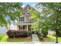 Inviting two-story home featuring a mix of brick and siding, a welcoming porch, and neat landscaping at 2638 Double Oaks Rd, Charlotte, NC 28206