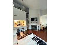 Bright living area with fireplace, dark hardwood floors, and an open kitchen design at 300 S Cedar St # 2, Charlotte, NC 28202